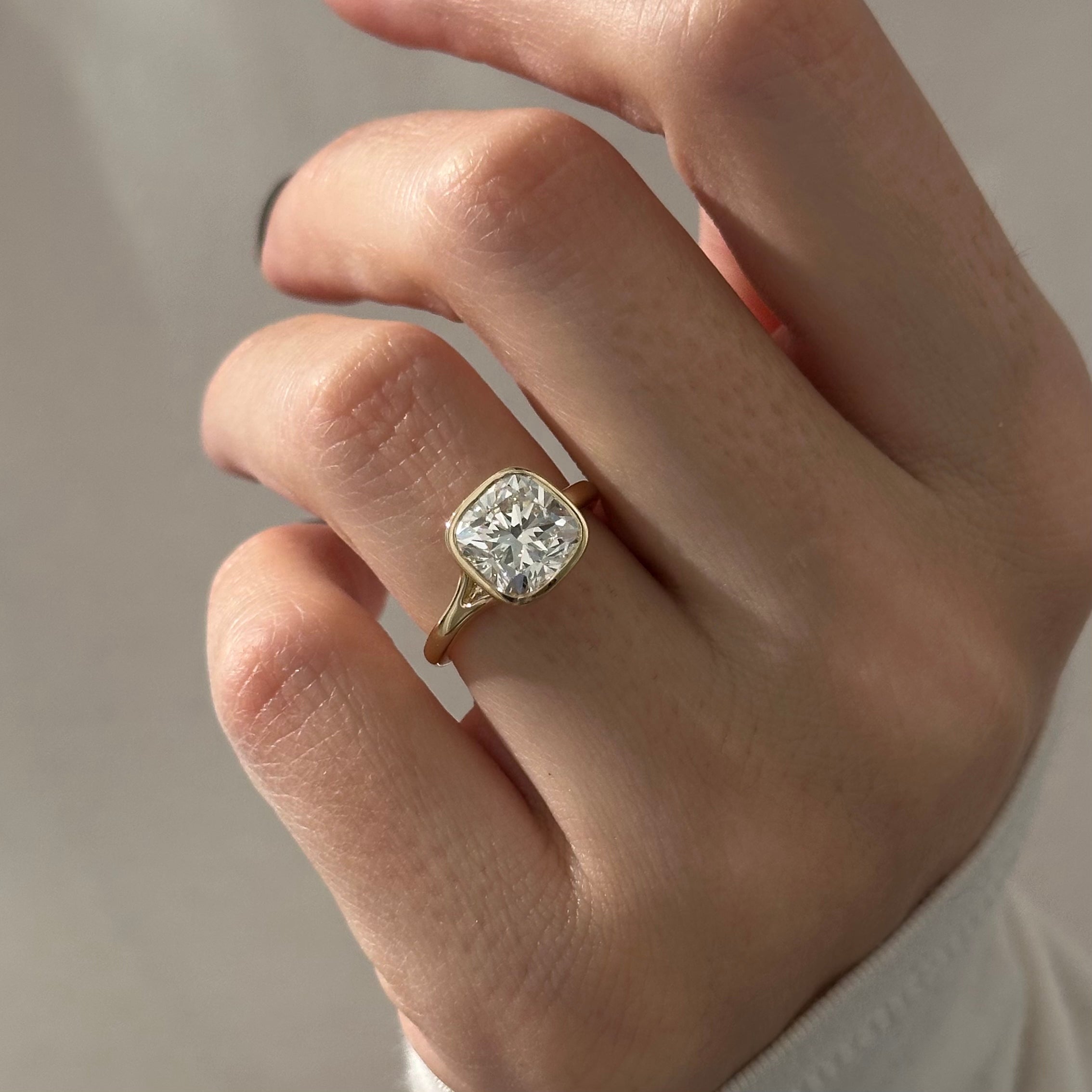 2 carat Cushion cut lab-grown diamond IGI certified, bezel engagement ring.