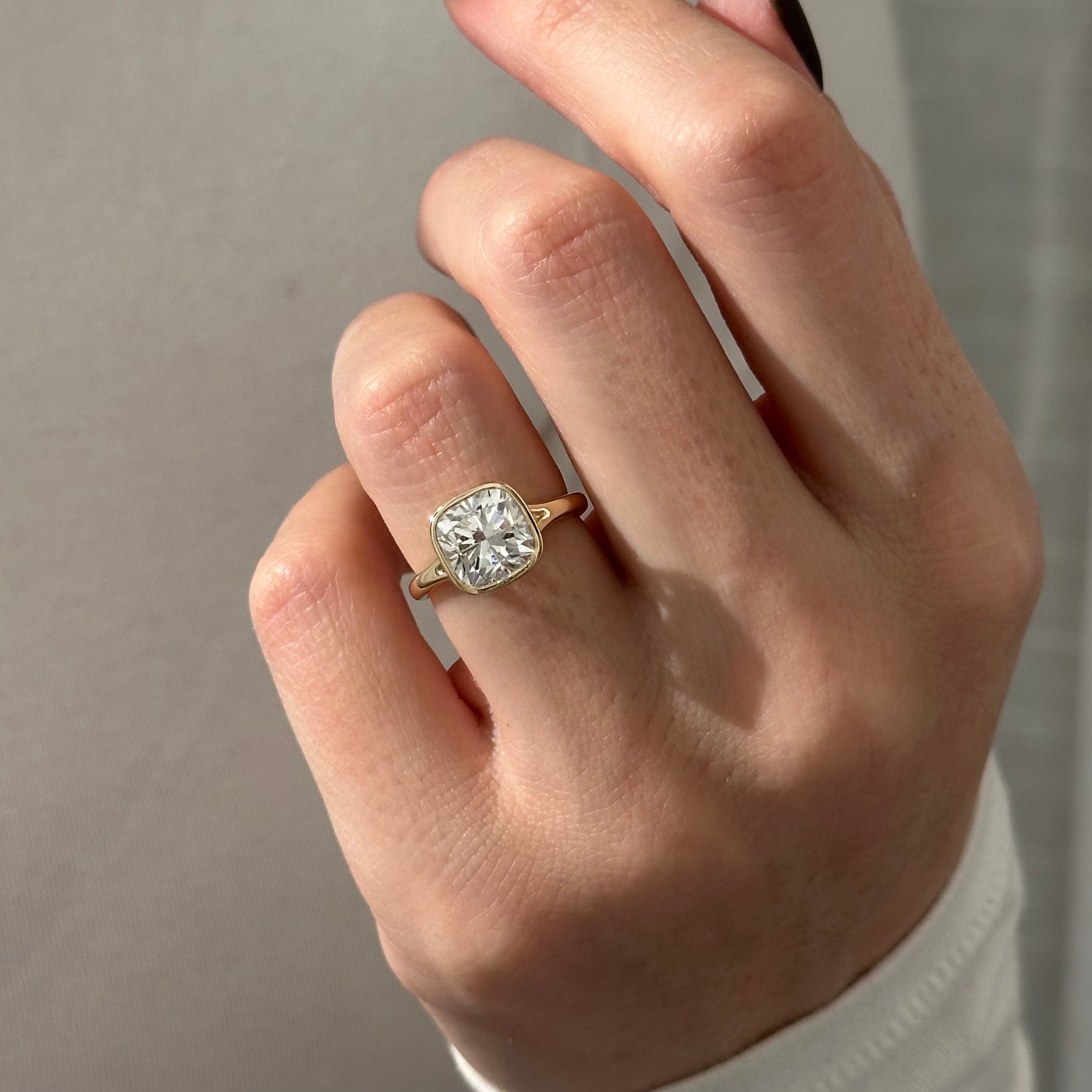 2 carat Cushion cut lab-grown diamond IGI certified, bezel engagement ring.
