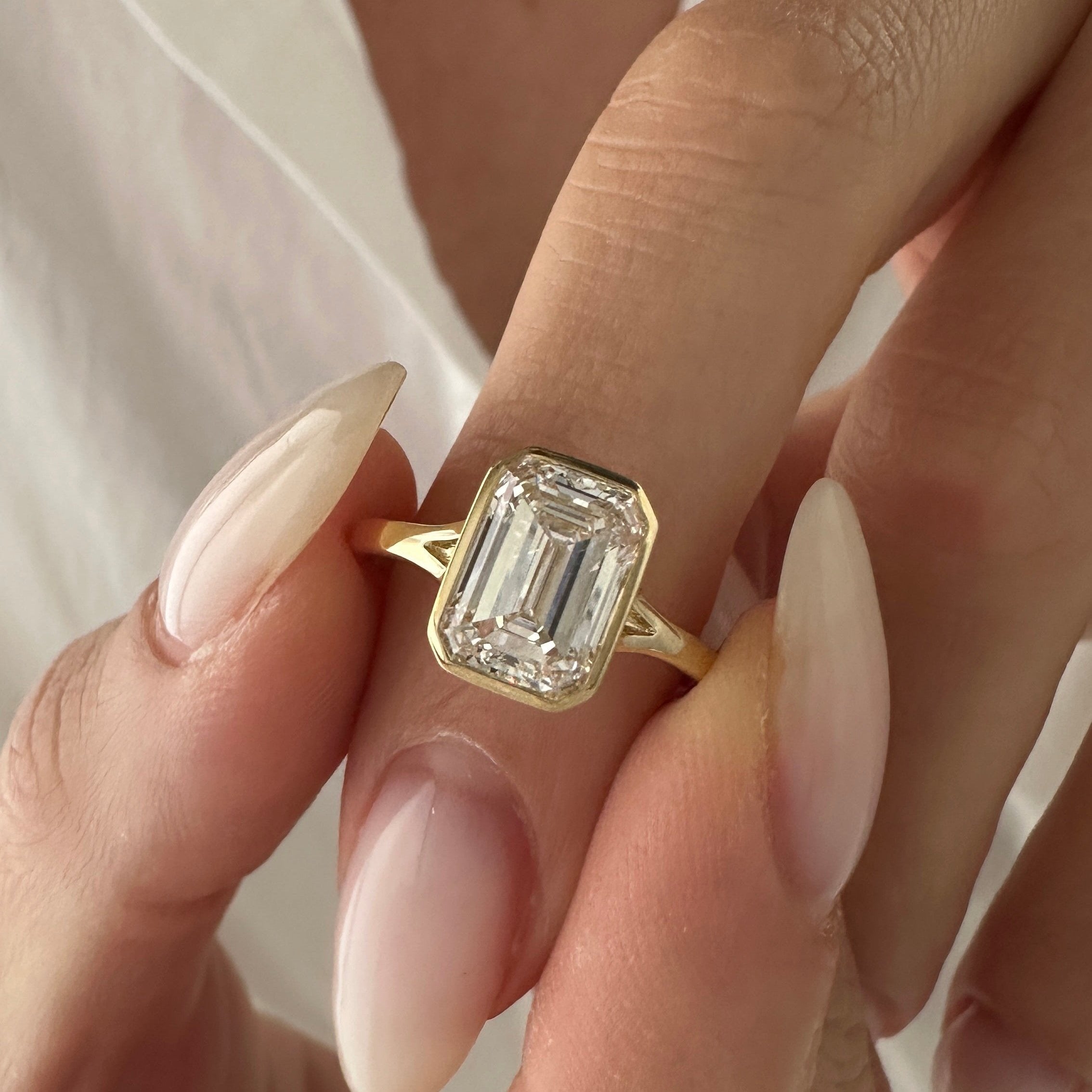all-groups | 2.5 carat Emerald cut lab-grown diamond IGI certified, bezel engagement ring.