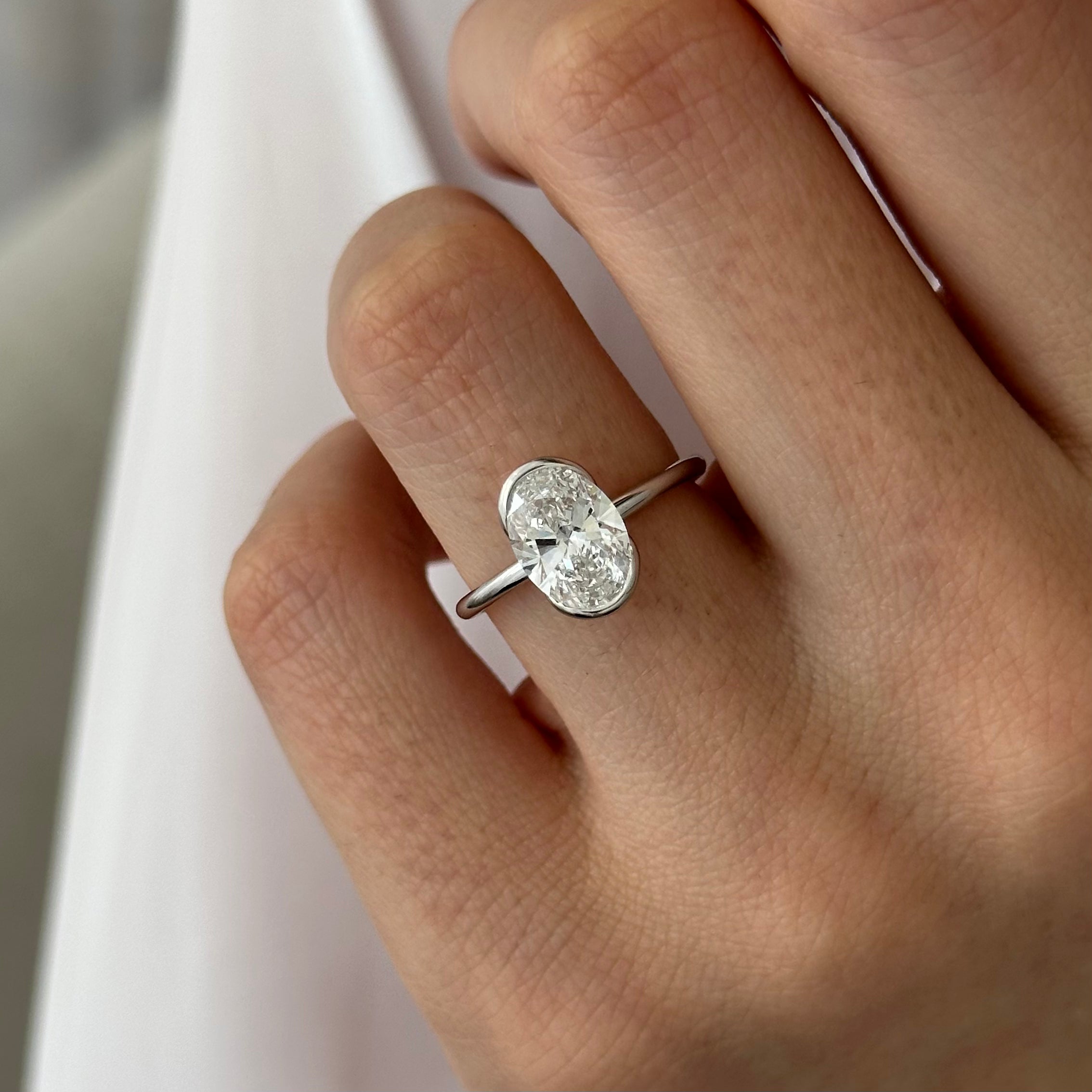 2 carat Oval cut lab-grown diamond IGI certified, bezel engagement ring.