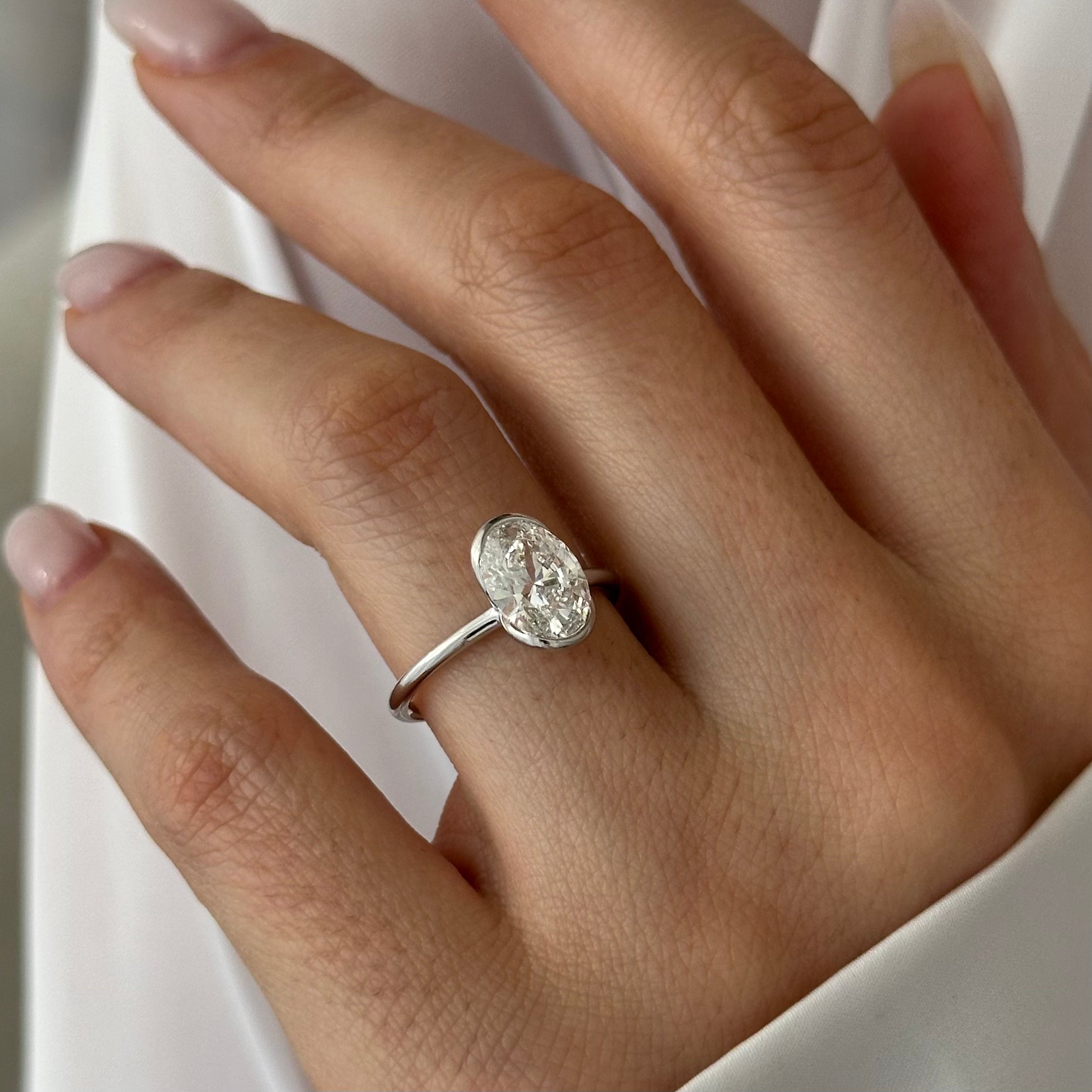 2 carat Oval cut lab-grown diamond IGI certified, bezel engagement ring.